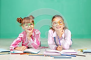 Two children laugh and read in glasses. The concept of childhood