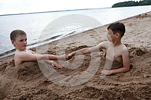 Two children play on sandy beach of Lake Seliger