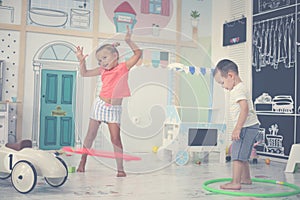 Two children in playground. Children spins hoolahope.