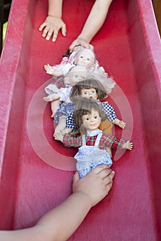 Two children playing with five dolls