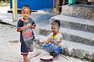 Two children playing sand cooking on the village road