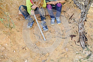 Two children playing with sand and dirt in an outdoor park, free child development