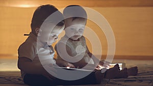 Two children playing with a tablet