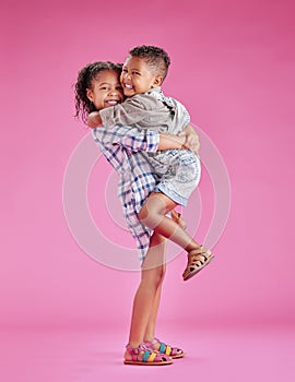 Two children only posing and being affectionate against a pink copyspace background. African American mixed race