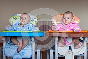 Two children in robes in high chair indoor