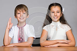 Two children seat at the desk