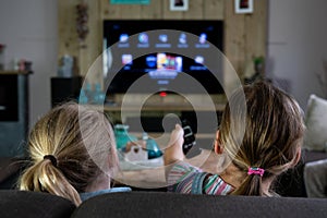 Two children sliding through the apps on a smart tv. back of the children with the focus on the children photo