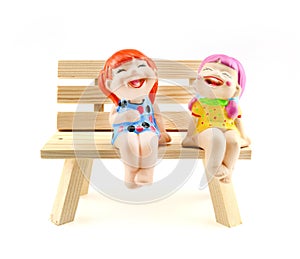 Two children statue to happy and smile , sitting on the wooden c