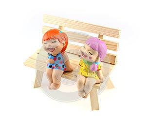 Two children statue to happy and smile , sitting on the wooden c