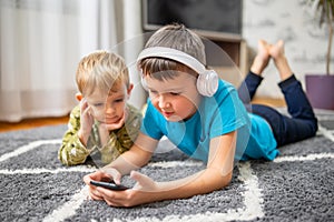 Two children watching smart phone, happy kids using smartphones together