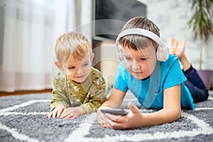 Two children watching smart phone, happy kids using smartphones together