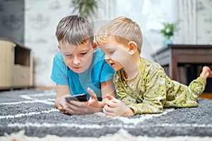 Two children watching smart phone, happy kids using smartphones together