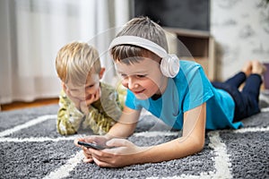 Two children watching smart phone, happy kids using smartphones together