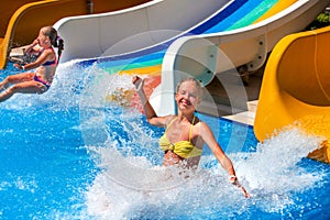 Two children on water slide at aquapark.