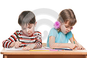 Two children write at the desk