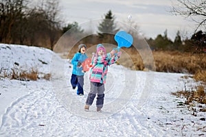 Two children of younger school age spend time in winter day with pleasure.