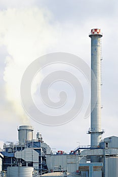 Two chimneys in a factory emitting smoke damaging the environment.