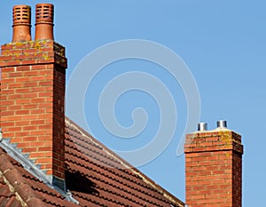 Two chimneys on a house with blue sky