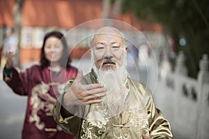 Two Chinese People Practicing Tai Ji in Traditional Costume