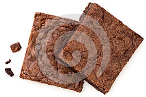 Two chocolate brownies with chocolate chips next to crumbs isolated on white from above