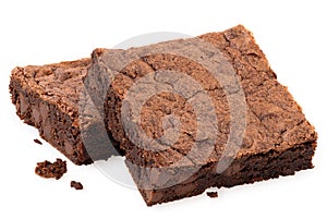 Two chocolate brownies with chocolate chips next to crumbs isolated on white