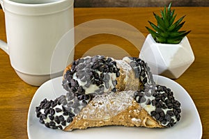 Two chocolate chip cannolis with coffee