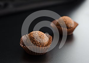 Two chocolate sweets over black