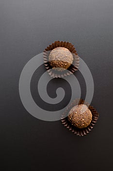 Two chocolate sweets over black
