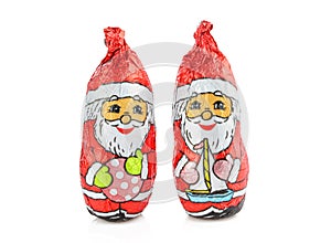 Two chocolate wrapped in foil santas isolated on white background. Holiday treats