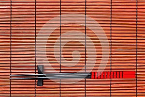 Two chopsticks on sushi mat background