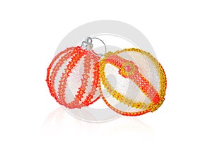Two Christmas balls decorated with beads on a white background