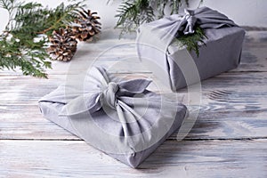 Two christmas gifts wrapped in gray linen cloth, zero waste concept