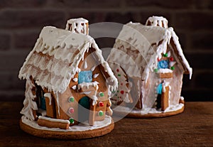 Two Christmas gingerbread houses decorated with sugar icing and colorful candy