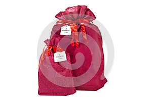 Two Christmas presents wrapped in a burgundy fabric with a ribbon, with the inscription `a gift for you` on a piece of paper, isol