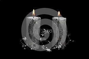 Two Christmas silver candles on the black background