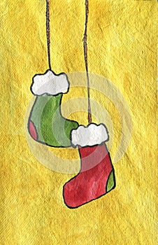 Two Christmas stockings, red and green hanging. Yellow background.