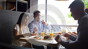 Two ciples of friends telling the story at the cafe suring breakfast - pizza, juice, desserts