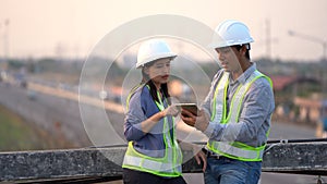 Two civil Engineering working with tablet on bridge highway