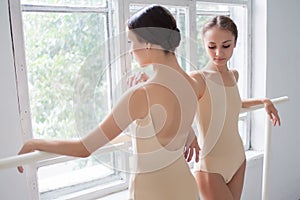 The two classic ballet dancers posing at barre