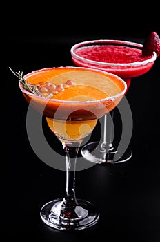 Two classic and strawberry margarita, white and red alcoholic cocktail with decoration of salt on the edge of the glass