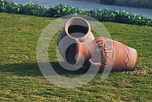 Two Clay amphora jug, old ceramic vases on green grass lawn near sea