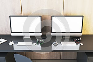 Two clean white gaming computer monitor on desk with coffee cups and headsets. Place for your advertisement. Gaming club concept.