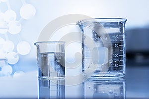 Two clear beaker with water in chemical science laboratory research background