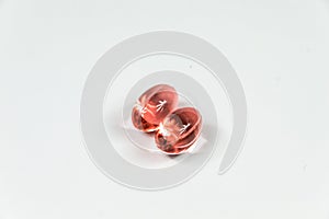 Two clear red soft gelatine capsules.