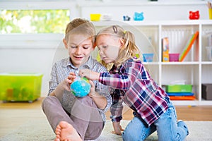 Two clever children exploring globe