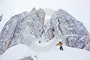 Two climbers approach to a winter steep face photo