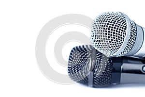 Two close-up of microphones on white background with copy space, selective focus photo