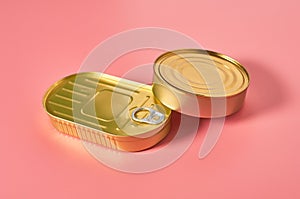 Two closed packagings of canned food on pink