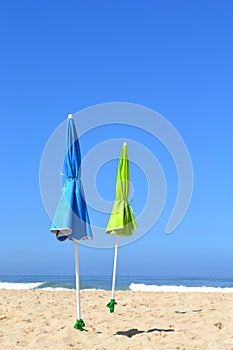 Two closed parasols on the beach