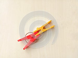 Two clothes pins, red and yellow.